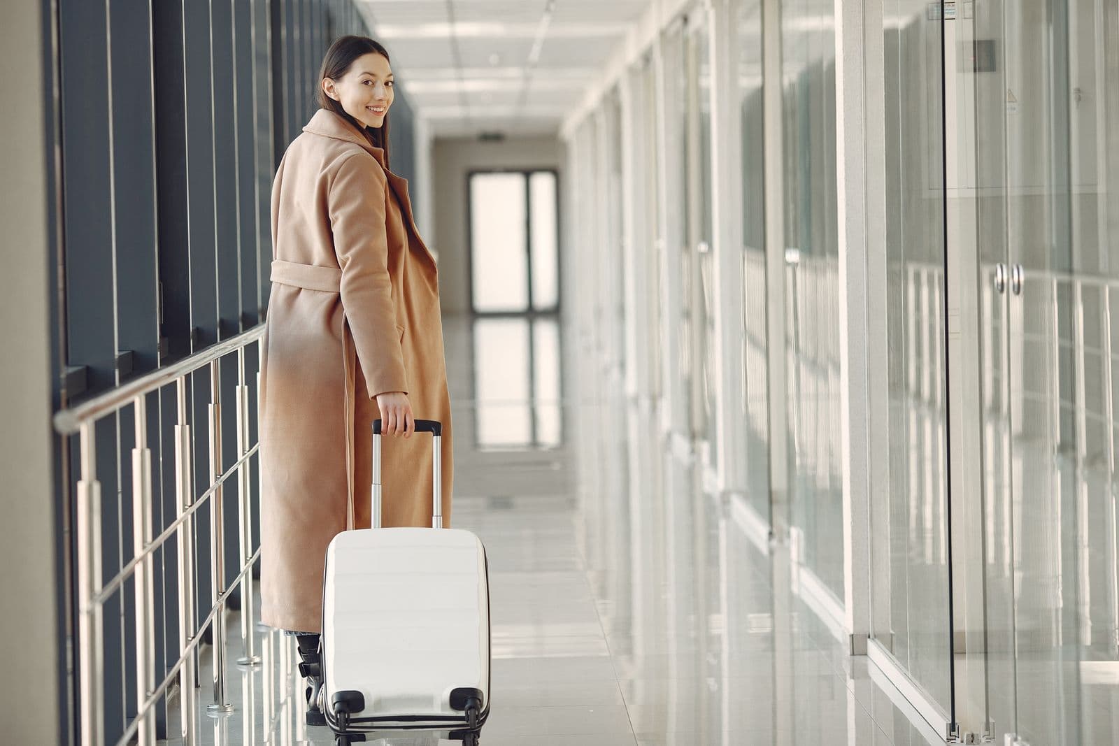 Voyageuse élégante avec sa valise dans un aéroport